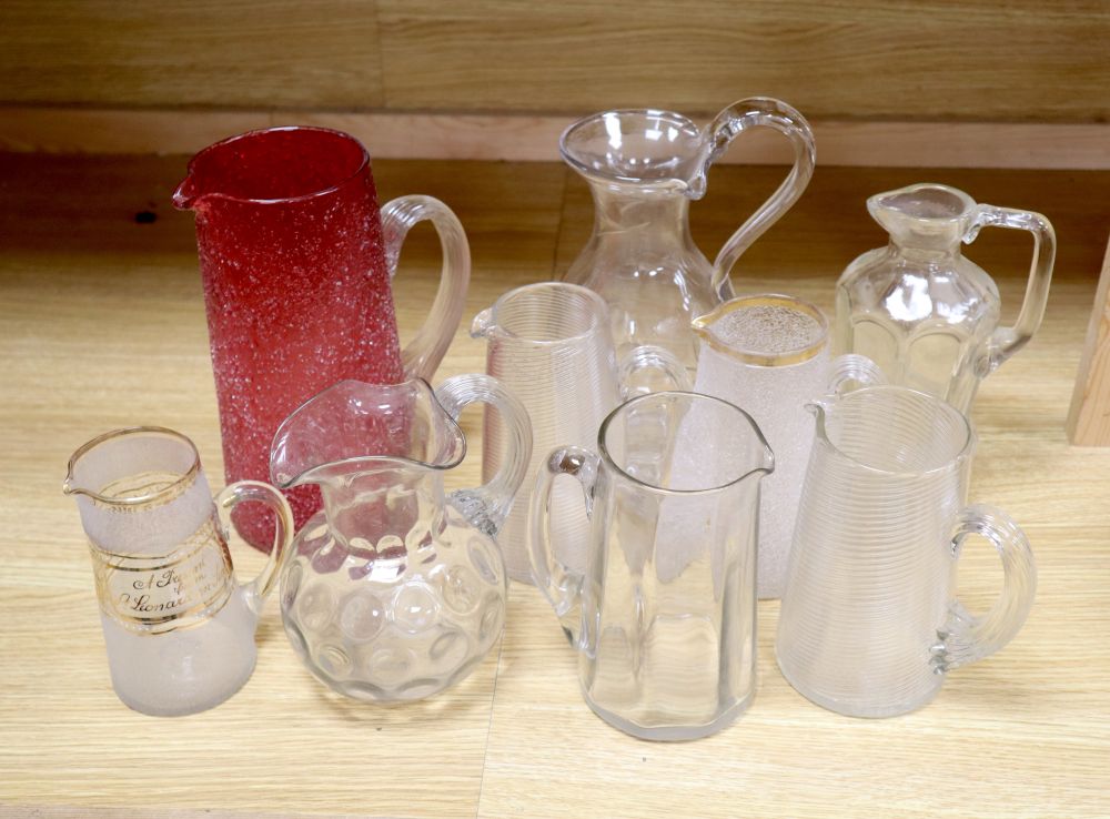 Nine various 19/20th century glass jugs, including a ruby crackle glass jug, tallest 25.