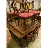 A late Victorian walnut extending dining table with two spare leaves and ten Victorian style