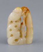 A Chinese pale celadon and russet jade carving of a bird on rockwork next to bamboo, 5.3cm