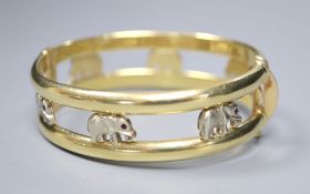 A two colour 585 hinged double bangle, pierced with elephants with red stone eyes, gross 30g,