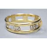 A two colour 585 hinged double bangle, pierced with elephants with red stone eyes, gross 30g,