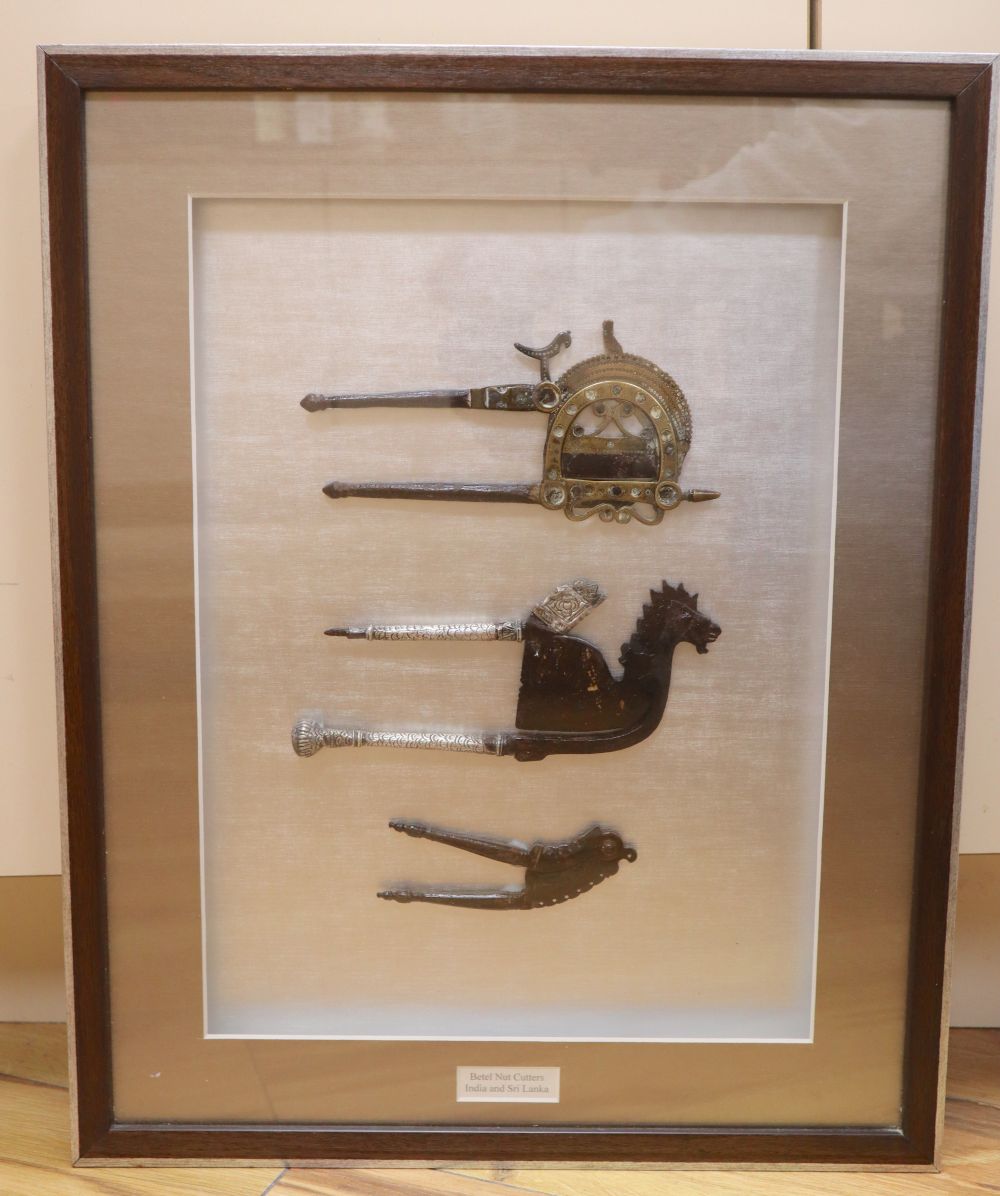 A framed display of three Betel nut cutters from India and Sri Lanka, framed 50 x 40cm