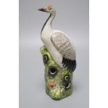 A Chinese enamelled porcelain model of a crane, 19th / 20th century, standing on a pine tree