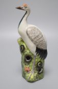 A Chinese enamelled porcelain model of a crane, 19th / 20th century, standing on a pine tree