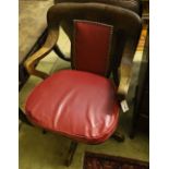 A 1920's oak swivel desk chair, the back and seat cushion covered in red hide, width 63cm, depth