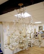 A French cream painted eight branch chandelier with painted cream leaves and crystal flowers, height