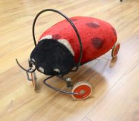 A vintage Steiff child's ride-on mohair ladybird, approx. length 54cm