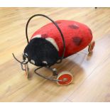 A vintage Steiff child's ride-on mohair ladybird, approx. length 54cm