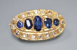 A yellow metal, graduated five stone sapphire and round cut diamond set oval brooch, 28mm, gross 5.8