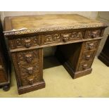 A 19th century Flemish carved oak kneehole desk, width 106cm depth 60cm height 75cm