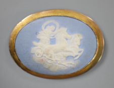 A late Victorian yellow metal mounted oval Wedgwood plaque brooch, depicting a maiden with chariot