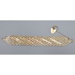 A 9ct gold articulated brick-link bracelet with heart-shaped padlock clasp, 16.6cm, 32.5g.CONDITION: