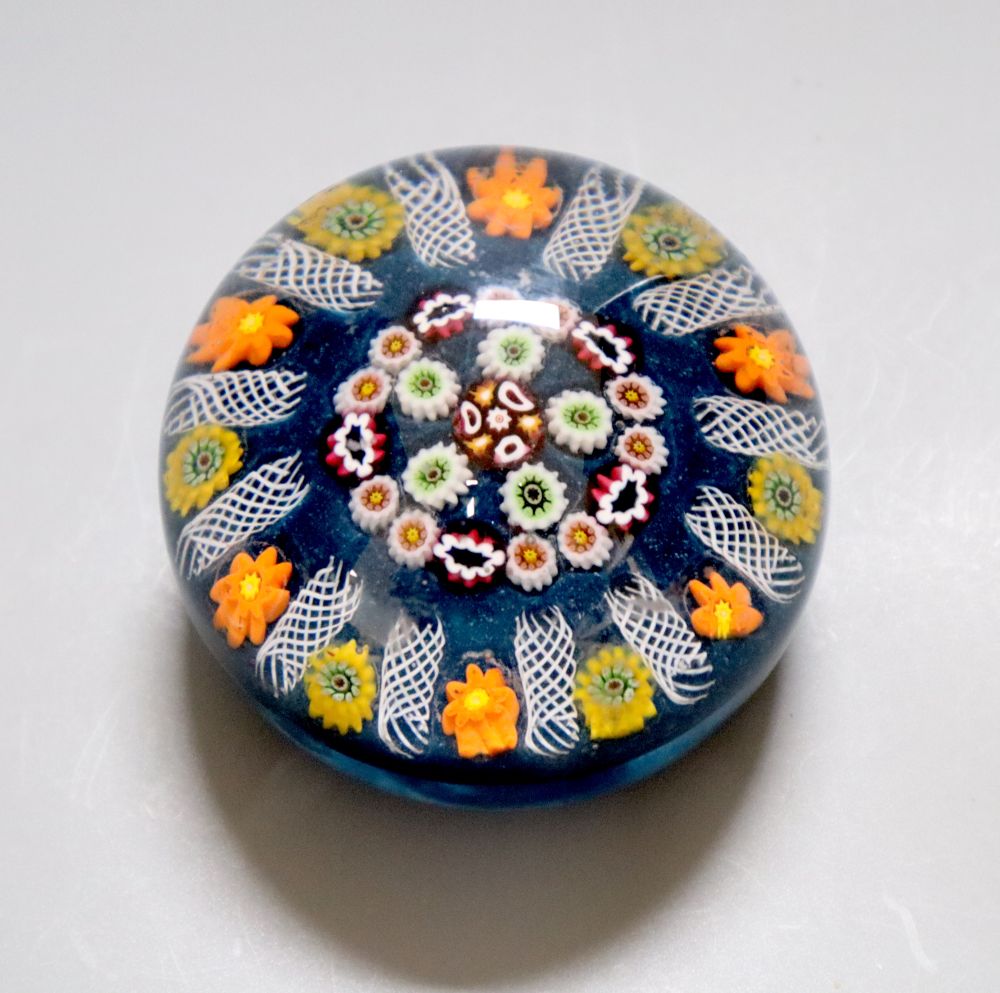 A large Scottish millefiori glass paperweight, with latticino divisions, on a blue ground, 8cm