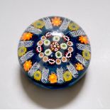 A large Scottish millefiori glass paperweight, with latticino divisions, on a blue ground, 8cm