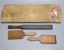 A 19th century Continental beech board, 53cm, a pair of beech butter pats and a mahogany paddle