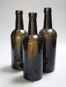 Three 19th century Trinity College Common Room sealed green glass wine bottles, the seals marked