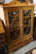 A glazed pine two door bookcase, width 112cm depth 26m height 150cm