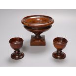 A 19th century turned amboyna urn, 11cm and two late Georgian turned mahogany egg cups, 6.5cm