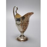 A George III silver helmet shaped cream jug, with later embossed decoration, Charles Hougham,