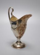 A George III silver helmet shaped cream jug, with later embossed decoration, Charles Hougham,