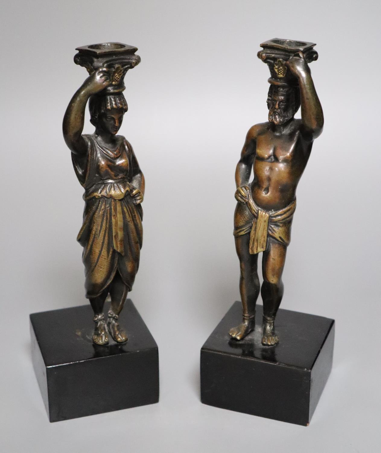 A pair of 19th century bronze figural candlesticks (once part of a clock), indistinctly stamped to