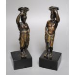 A pair of 19th century bronze figural candlesticks (once part of a clock), indistinctly stamped to