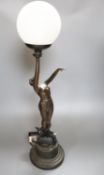 An Art Deco style bronzed resin figural table lamp, semi-nude female holding glass shade aloft, 66cm