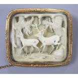 A 19th century Austro-German yellow metal framed brooch, inset with carved ivory forest scene