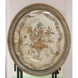 An early 19th century silkwork panel of flowers in a cornucopia, oval 50 x 42cmCONDITION: Embroidery