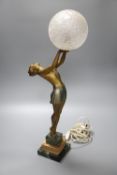 An Art Deco spelter table lamp, with female holding glass shade aloft, on stepped square base, 55cm