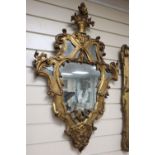 A pair of Italian rococo style carved giltwood wall mirrors, width 56cm, height 88cm