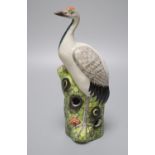 A Chinese enamelled porcelain model of a crane, 19th / 20th century, standing on a pine tree