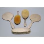 Two late 1920's silver mounted hand mirrors and three silver mounted brushes.