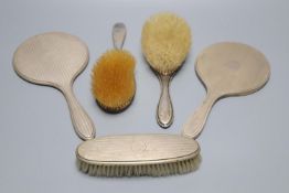 Two late 1920's silver mounted hand mirrors and three silver mounted brushes.