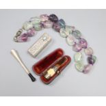 Two white metal cigarette holders, an 800 lipstick holder and a quartz necklace.