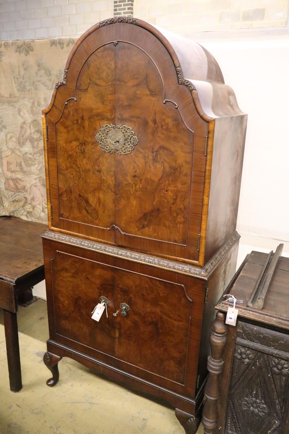 A burr walnut cocktail cabinet, width 81cm, depth 50cm, height 177cm with a collection of Tudor