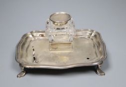 An Edwardian silver inkstand with mounted glass well and pen rest (one rest missing), William Hutton