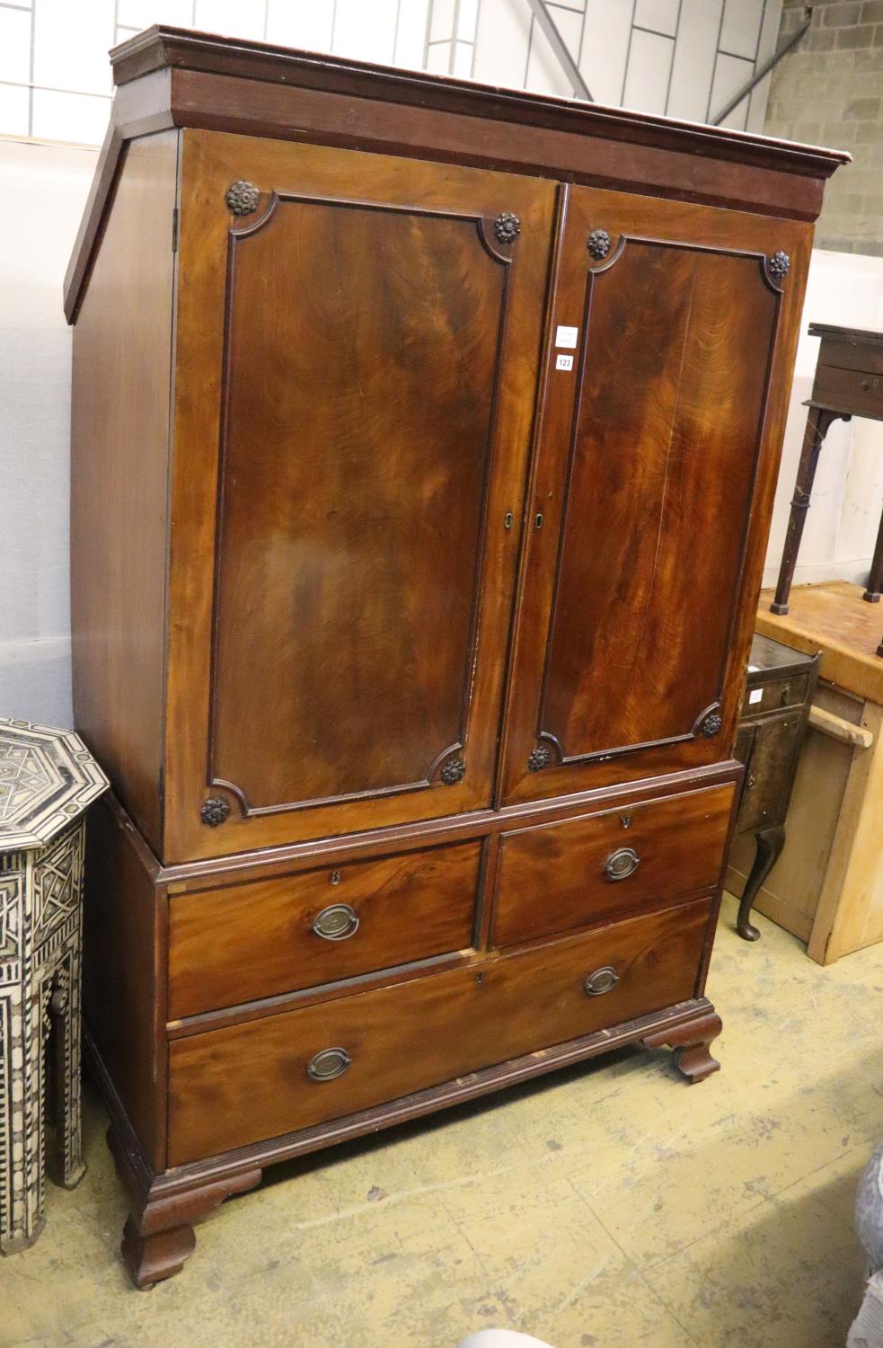 A Regency mahogany linen press, width 124cm, depth 60cm, height 192cm (top cut to fit eaves)