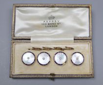 A cased set of four early 20th century 9ct, mother of pearl and enamel buttons, in Asprey box.