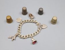 A silver charm bracelet hung with four assorted charms and four thimbles including two silver.