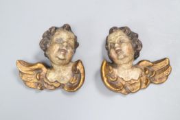 A pair of late 18th/early 19th century carved painted cherub heads, height 9cm.