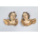 A pair of late 18th/early 19th century carved painted cherub heads, height 9cm.