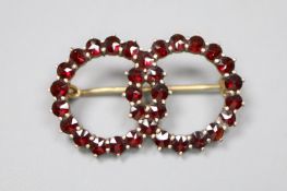 A late Victorian gilt white metal and facet cut garnet set twin sphere brooch, 30mm, gross 3.5