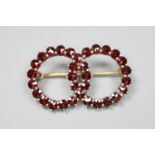 A late Victorian gilt white metal and facet cut garnet set twin sphere brooch, 30mm, gross 3.5