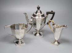 An Edwardian engraved silver three piece pedestal coffee set by James Deakin & Sons, Sheffield,