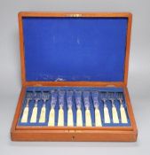 A Victorian set of twelve plated and engraved fish knives and forks, with carved ivory handles,