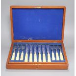 A Victorian set of twelve plated and engraved fish knives and forks, with carved ivory handles,