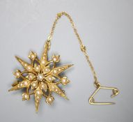 An Edwardian 15ct and graduated split pearl set starburst brooch, 31mm, gross 5.7 grams.