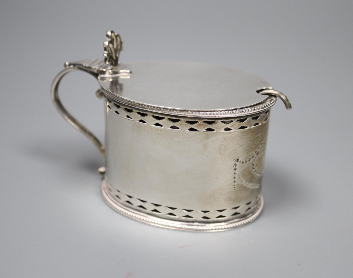 A George III pierced silver oval mustard pot, maker, W?, London, 1785, with blue glass liner and