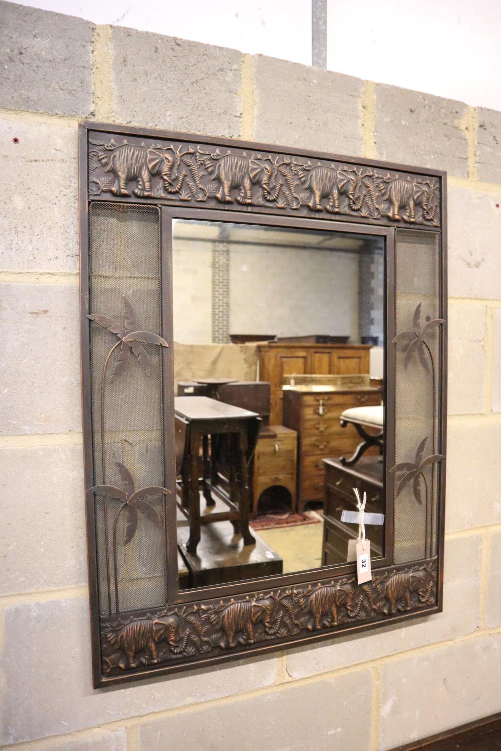 An Indian embossed wall mirror, the borders decorated with elephants, width 64cm, height 82cm